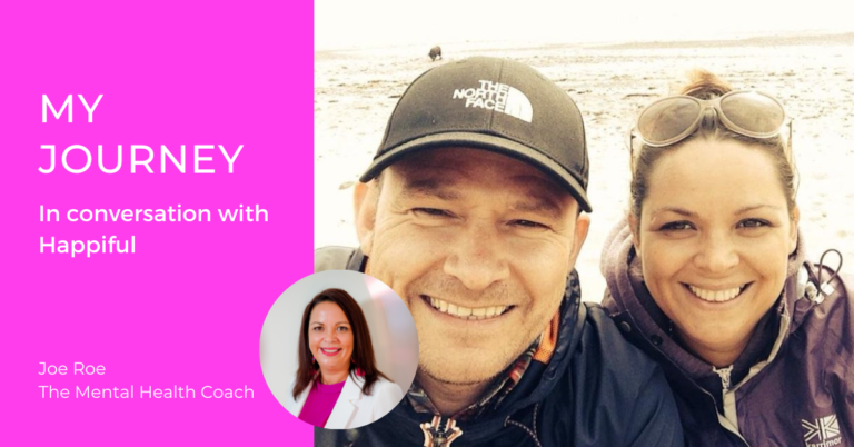 My journey from mental ill health to mental wellness coach, in conversation with Happiful magazine. Joe smiles in a photo from the article where she is at the beach with her partner.